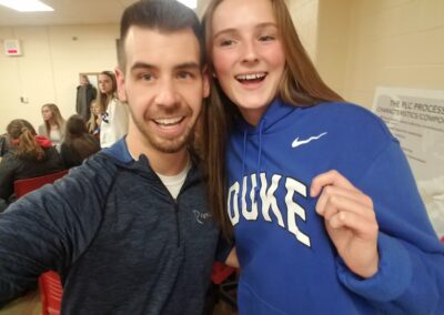 A man and a woman celebrating on college signing day while posing for a selfie.
