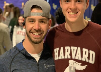 Two men standing next to each other at a college signing day event.