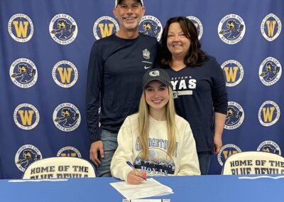 A girl sitting at the table with her parents.