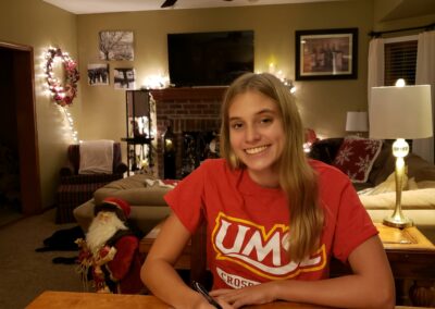 A girl sitting at the table in front of papers.